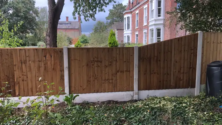 Run of new feather-edge fence on concrete posts and gravel boards