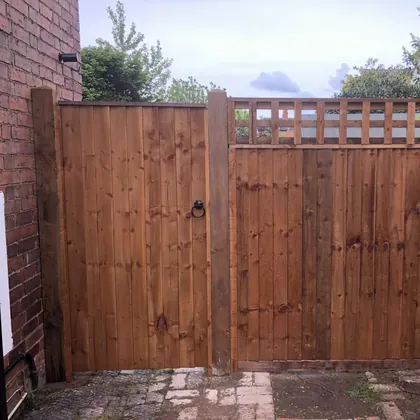 Timber side gate with ring latch beside a matching trellis-top panel